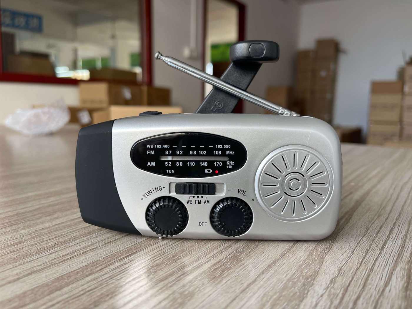 Hand crank emergency radio supplier product — silver dynamo radio with folding crank handle and telescopic antenna